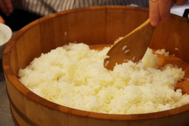 しゃもじで混ぜている酢飯