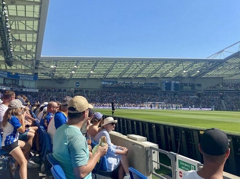 ブライトン&ホーヴ・アルビオンFCのホームスタジアムでサッカーの試合を観戦する人々